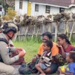 Sentuhan Humanis Satgas Damai Cartenz di Sinak Dengan Bagikan Makanan Ringan kepada Warga